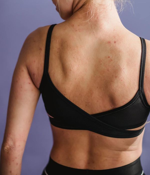 Woman in a calm yoga pose on a light cream background with purple accents.